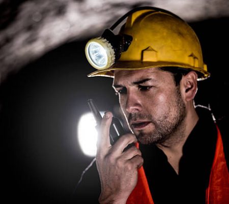 Portrait of a miner working at the mine and talking on a walkie-talkie